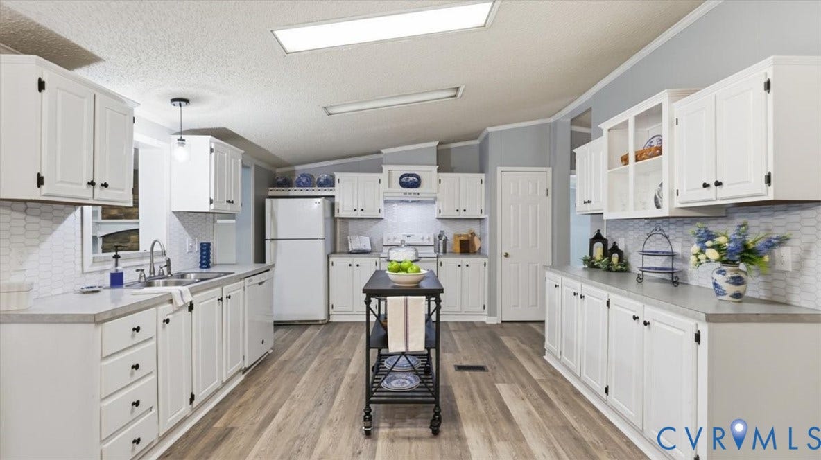 75 Claybank Road, Cumberland, VA 23040 Kitchen featuring white shaker-style cabinetry, wood-finish flooring, hexagonal tile backsplash, solid-surface countertops, and built-in glass-front display cabinets