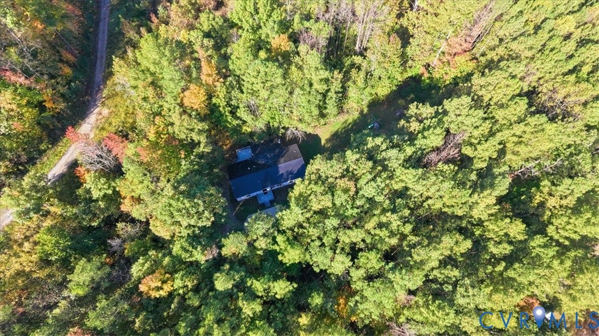 75 Claybank Road, Cumberland, VA 23040 Aerial perspective of a detached residence nestled within a densely wooded lot, featuring a shingled roof and a private gravel drive