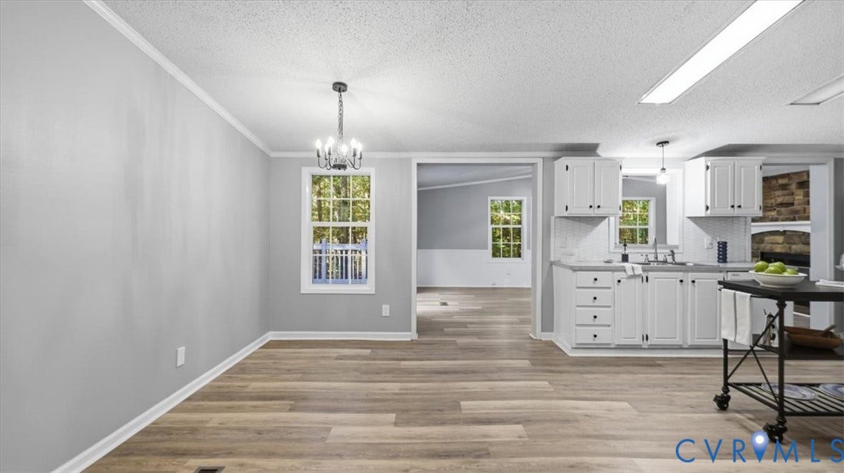 75 Claybank Road, Cumberland, VA 23040 Interior space featuring wood-finish flooring, white cabinetry, a multi-light chandelier, and expansive windows