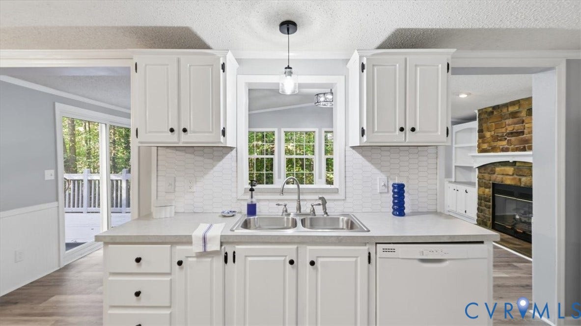 75 Claybank Road, Cumberland, VA 23040 Kitchen featuring white cabinetry, a dual-basin stainless steel sink with a pull-down faucet, a hexagonal tile backsplash, and an integrated dishwasher