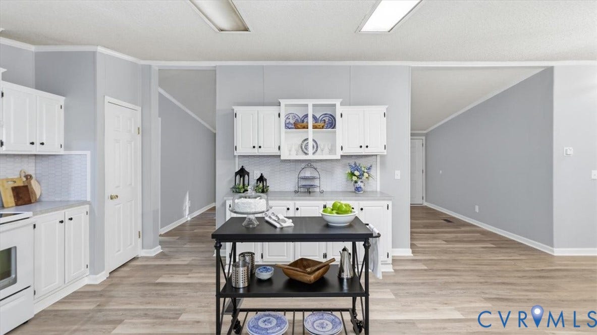 75 Claybank Road, Cumberland, VA 23040 Kitchen featuring white cabinetry with glass-front display shelving, neutral solid-surface countertops, wood-finish flooring, and recessed ceiling lighting