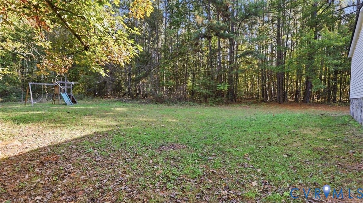 75 Claybank Road, Cumberland, VA 23040 Expansive backyard featuring a large grass lawn, mature trees, and a wooded perimeter