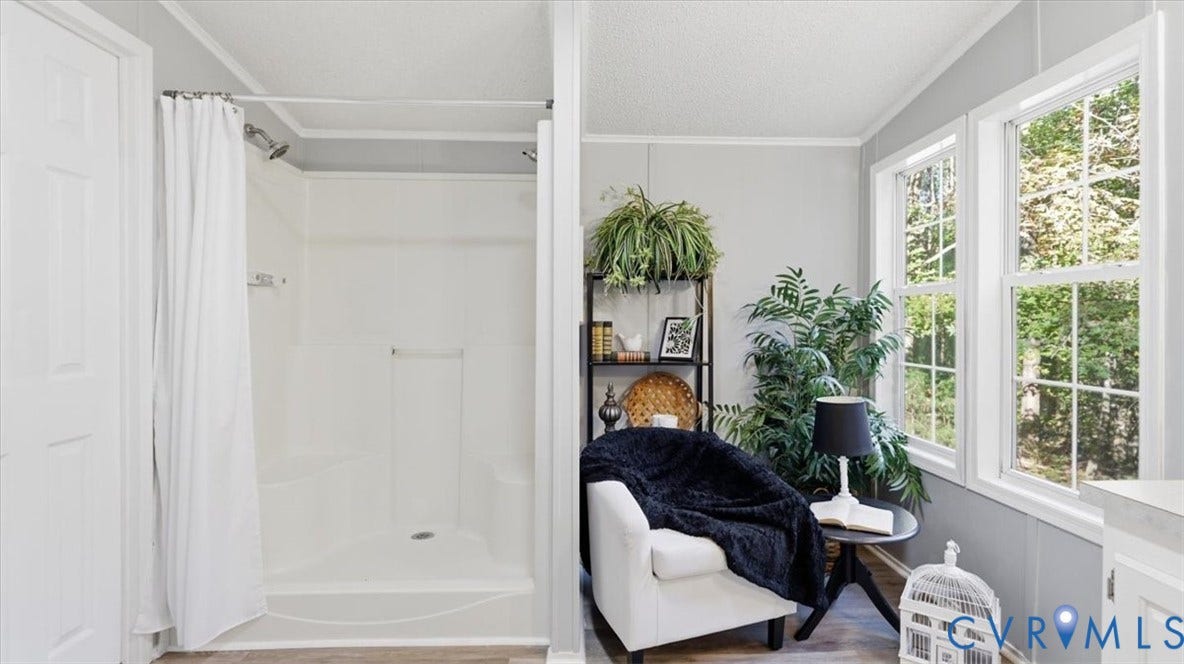 75 Claybank Road, Cumberland, VA 23040 White walk-in shower enclosure featuring an integrated corner seat, polished chrome fixtures, neutral wall color, and double-pane windows