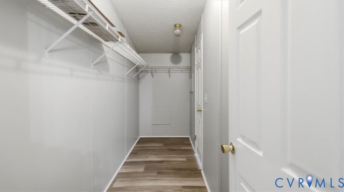 75 Claybank Road, Cumberland, VA 23040 Storage area featuring wood-finish flooring, white paneled doors, tiered metal shelving, and a central ceiling-mounted light fixture