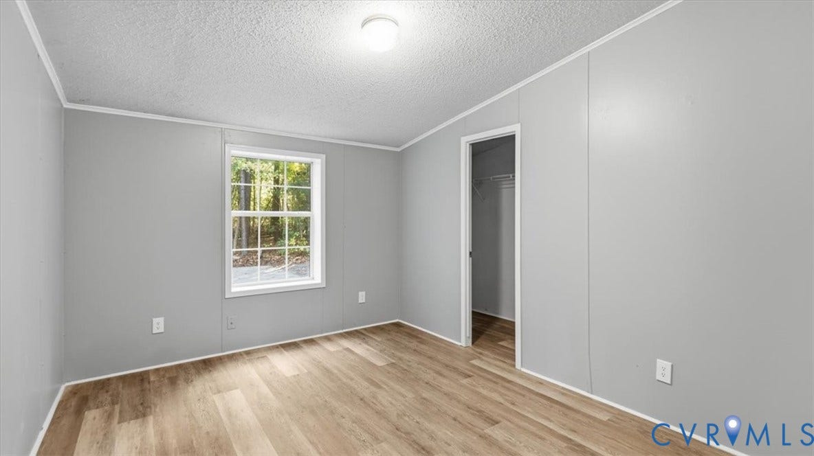 75 Claybank Road, Cumberland, VA 23040 Room featuring wood-finish flooring, neutral walls, a single-hung window, and a reach-in closet with integrated shelving