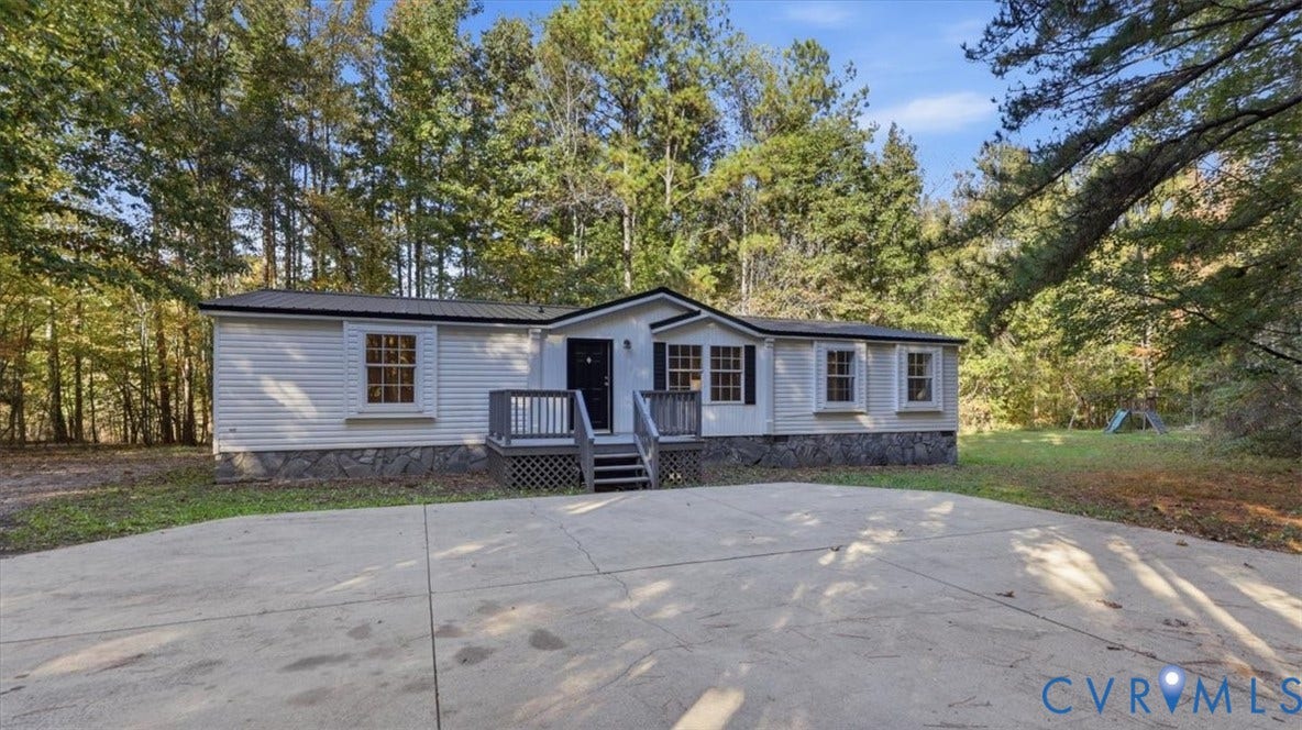 75 Claybank Road, Cumberland, VA 23040 Single-story exterior featuring light-toned horizontal siding, stone-patterned skirting, a metal roof, and a raised wooden front deck