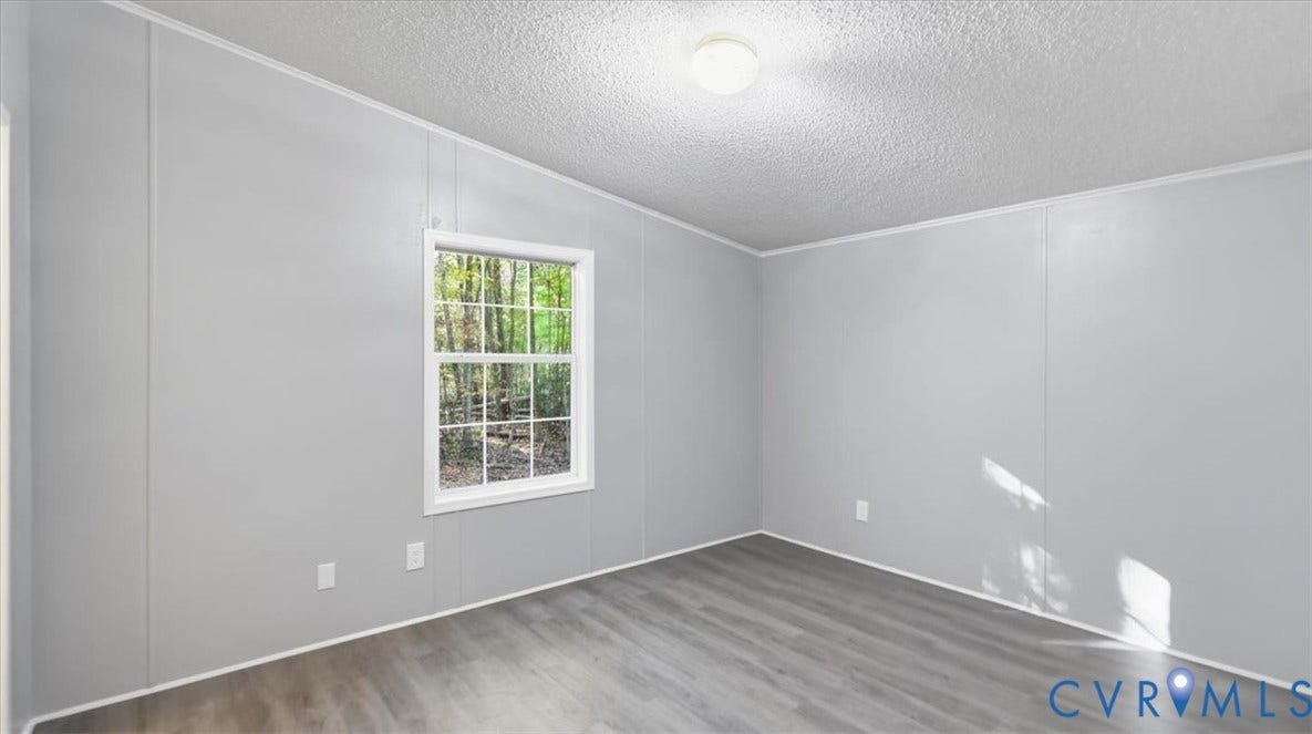 75 Claybank Road, Cumberland, VA 23040 Interior room featuring neutral-toned walls, wood-finish flooring, a single-hung window with a grid pattern, and a central ceiling-mounted light fixture