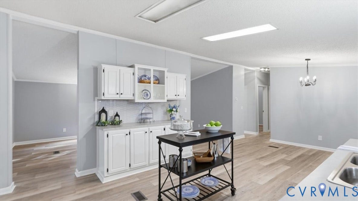 75 Claybank Road, Cumberland, VA 23040 Kitchen area featuring white cabinetry with glass-front detailing, light-toned wood-finish flooring, recessed lighting, and a multi-arm chandelier