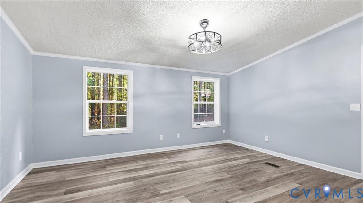 75 Claybank Road, Cumberland, VA 23040 Room featuring wood-finish flooring, dual windows with exterior wooded scenery, and a modern drum-style chandelier