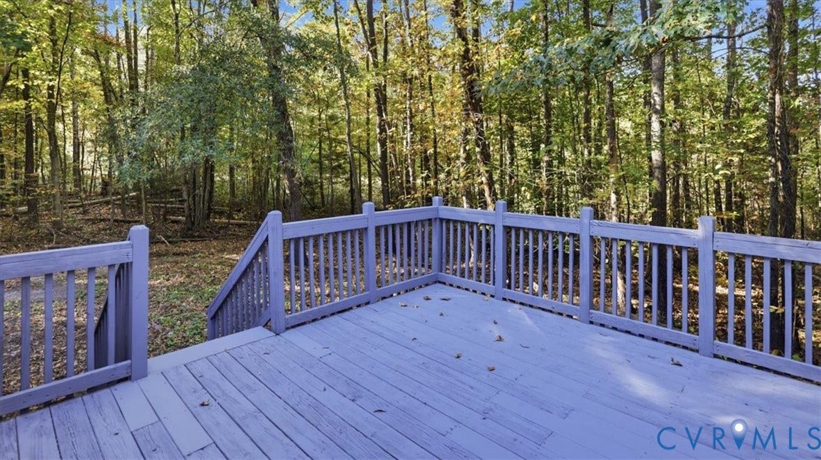 75 Claybank Road, Cumberland, VA 23040 Raised wood-finish deck with vertical railing and stairs leading to a wooded lot