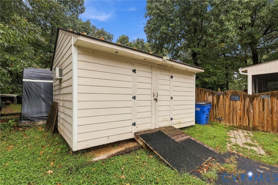 Storage structure with horizontal siding, double-door entry, and a dedicated ramp