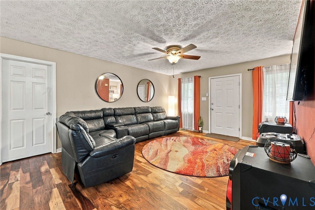 Wood-finish flooring, ceiling fan with integrated lighting, and white six-panel interior doors