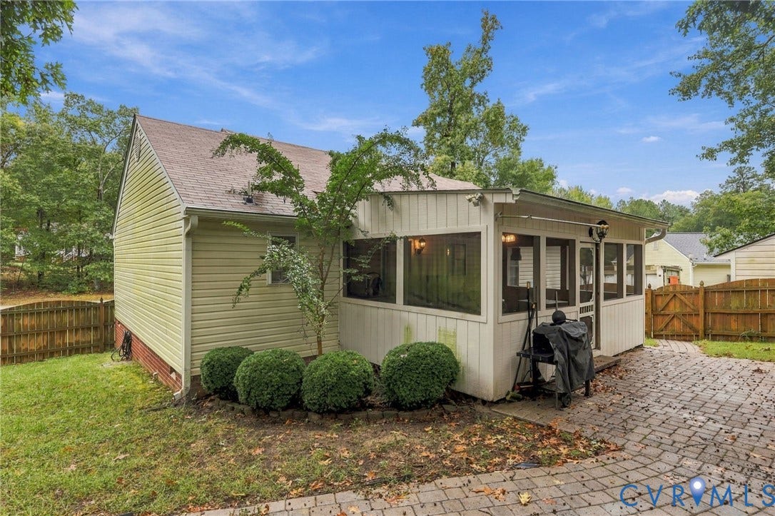 Screened-in porch with wood-paneled walls and ceiling, brick-paver patio, vinyl siding, and wood-slat privacy fencing