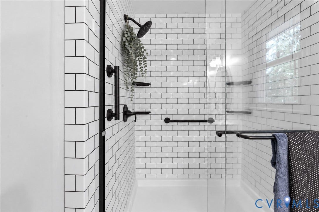 3621 Jefferson Highway, Mineral, VA 23093 Walk-in shower featuring white subway tile surround, matte black rainfall showerhead, glass door enclosure, and integrated black metal grab bars
