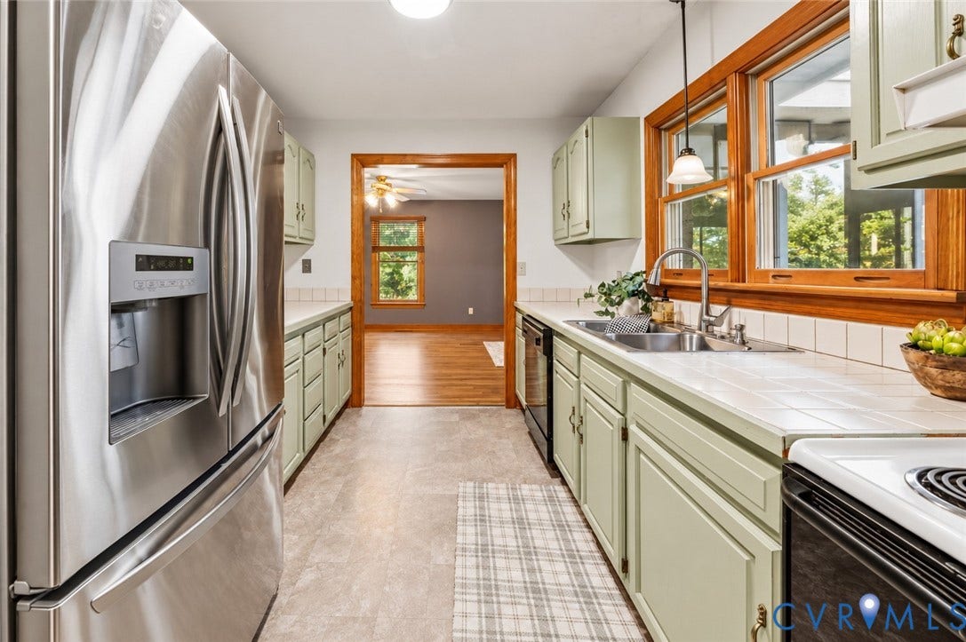 3621 Jefferson Highway, Mineral, VA 23093 Kitchen featuring stainless steel refrigerator, tile countertops, wood-finished cabinetry, double-basin sink with gooseneck faucet, and wooden window trim