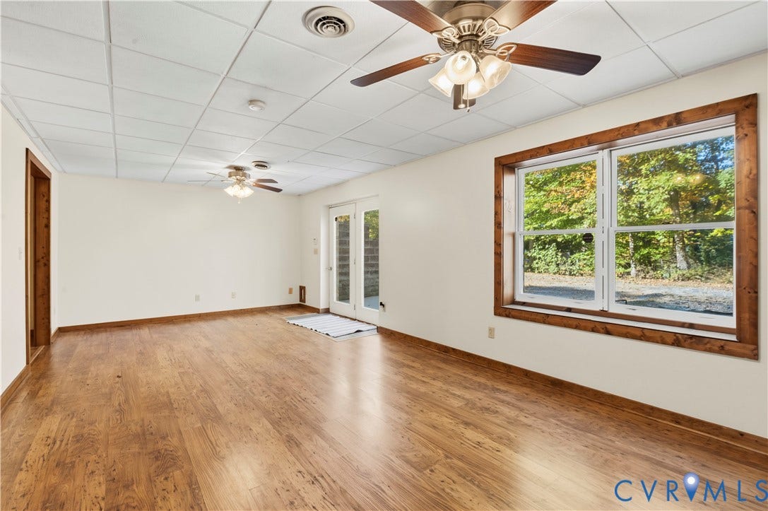 3621 Jefferson Highway, Mineral, VA 23093 Interior space featuring wood-finish flooring, dual ceiling fans, a drop ceiling, and a large window framed in natural wood trim
