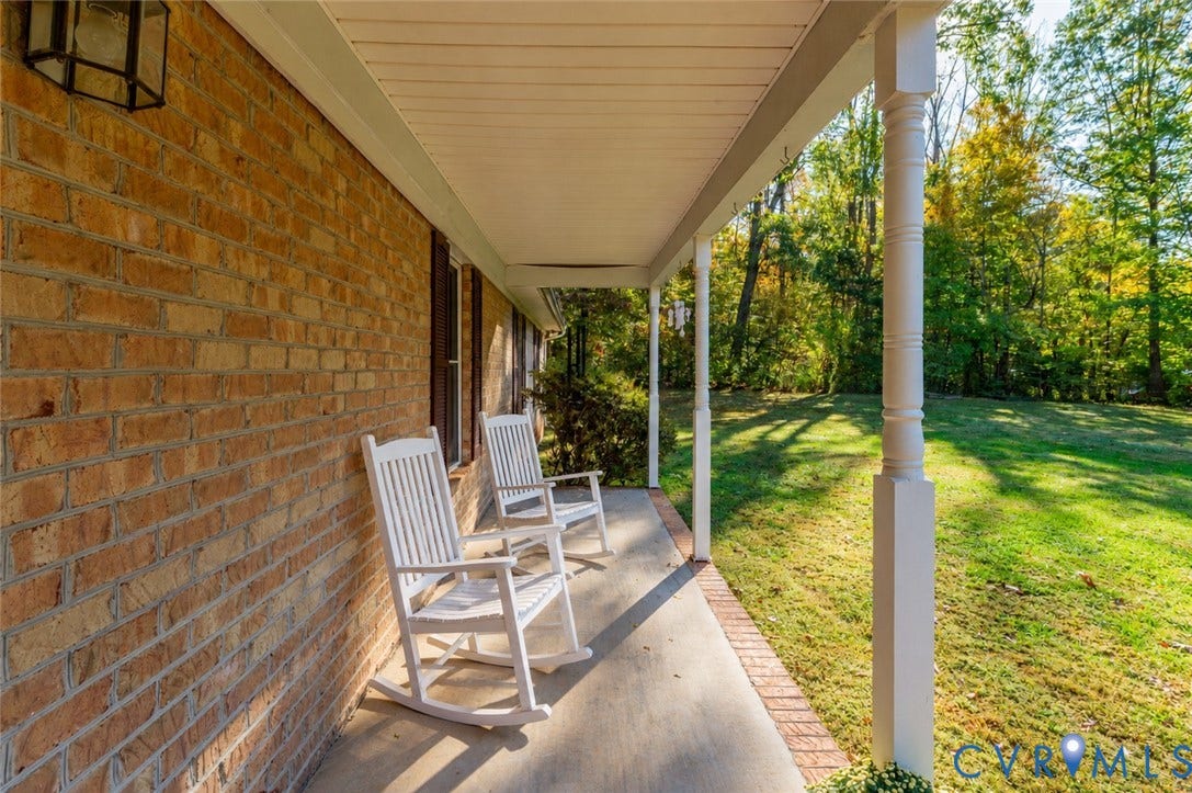 3621 Jefferson Highway, Mineral, VA 23093 Covered porch featuring a brick exterior facade, concrete flooring, decorative wood columns, and an attached wall-mounted lantern