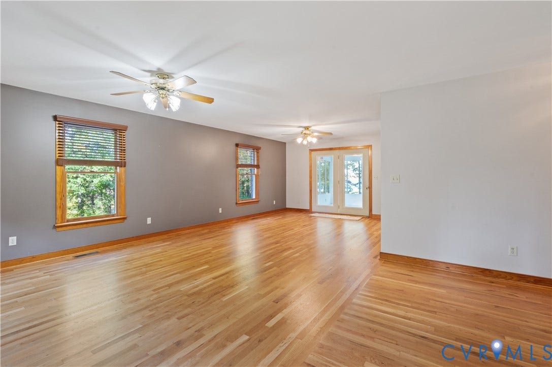 3621 Jefferson Highway, Mineral, VA 23093 Spacious interior featuring wood-finish flooring, dual ceiling fans with integrated lighting, wood-framed windows, and glass-paneled exterior doors