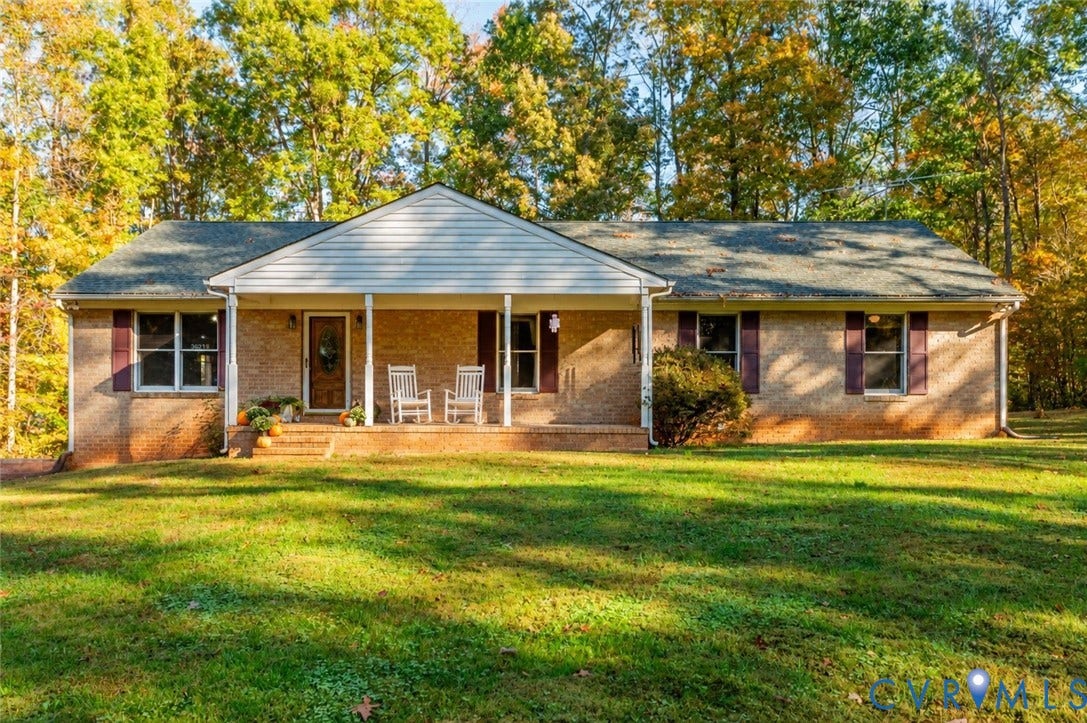 3621 Jefferson Highway, Mineral, VA 23093 Single-story brick exterior featuring a covered front porch, gabled roofline, and mature wooded surroundings
