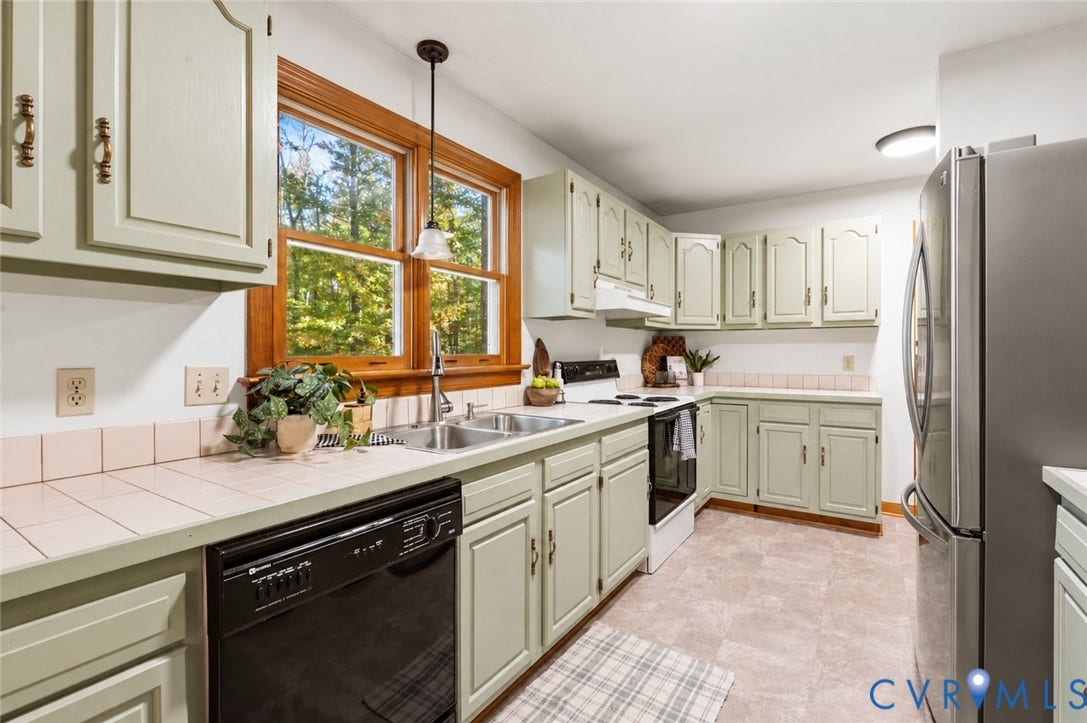 3621 Jefferson Highway, Mineral, VA 23093 Kitchen featuring custom cabinetry, tile countertops, a double basin stainless steel sink, wood-trimmed window, and pendant lighting