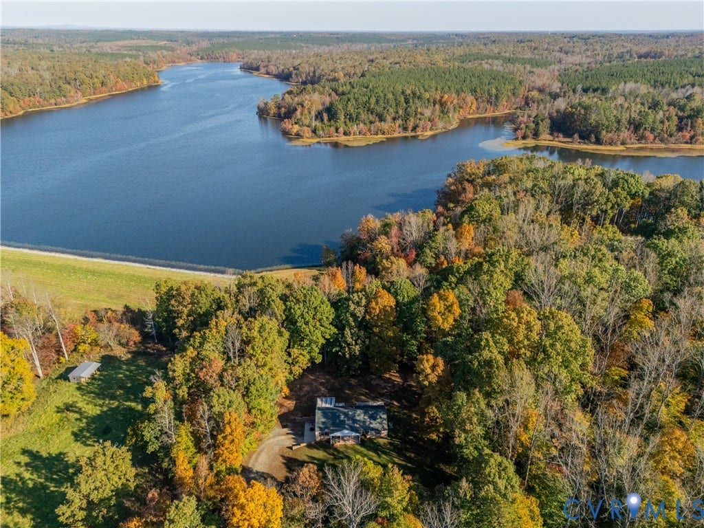 3621 Jefferson Highway, Mineral, VA 23093 Aerial perspective of expansive wooded acreage featuring direct waterfront access, a primary structure with a metal roof, and a private gravel drive