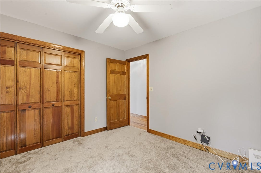 3621 Jefferson Highway, Mineral, VA 23093 Neutral-toned carpeted flooring, wood-finish closet doors, six-panel wood door, and a ceiling-mounted light fixture with a multi-blade fan