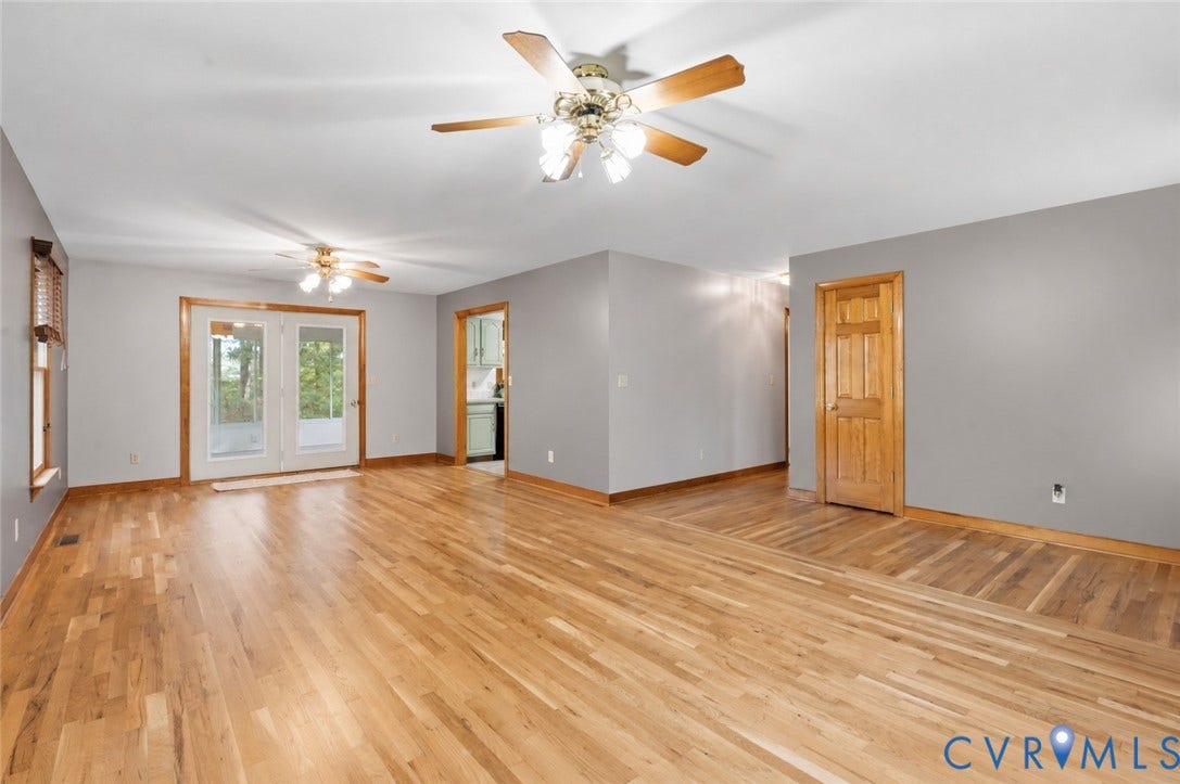 3621 Jefferson Highway, Mineral, VA 23093 Open-concept interior featuring wood-finish flooring, neutral wall paint, dual ceiling fans, and glass-paneled double doors