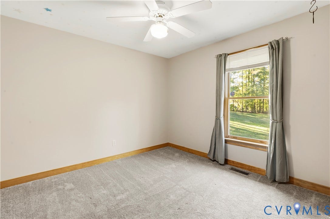 3621 Jefferson Highway, Mineral, VA 23093 Neutral-toned carpeting, wood trim, white ceiling fan with integrated light fixture, and a single-pane window