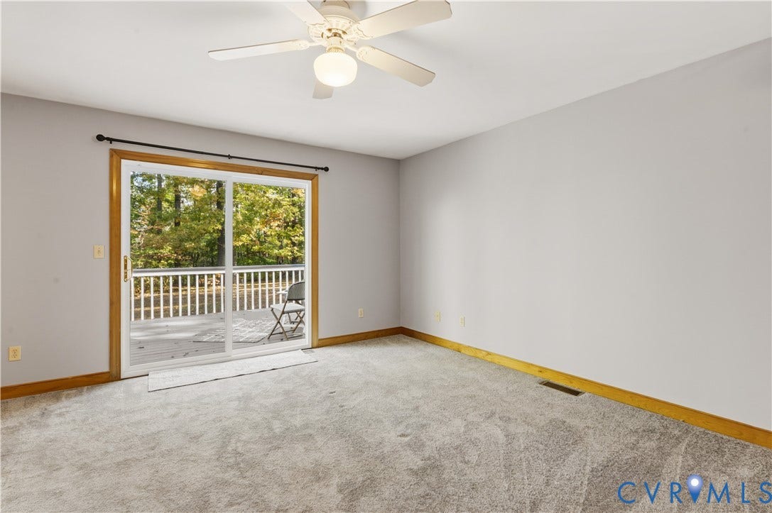 3621 Jefferson Highway, Mineral, VA 23093 Neutral-toned carpeting, sliding glass doors with wood-finish trim, and a ceiling-mounted light fixture with a multi-blade fan