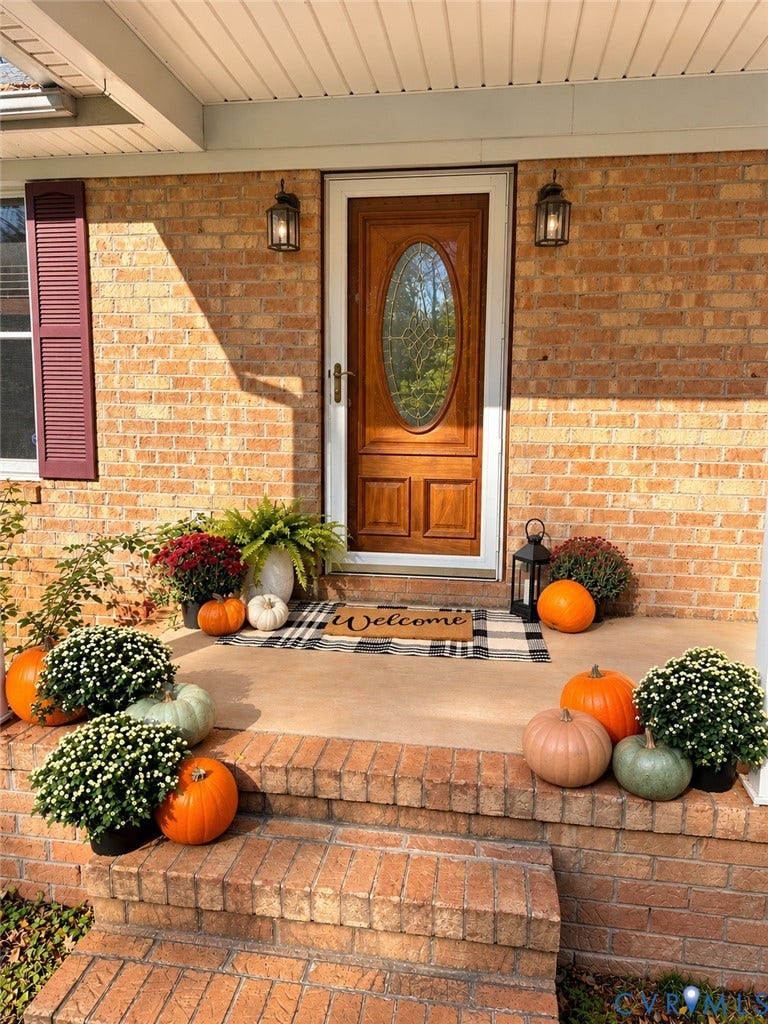 3621 Jefferson Highway, Mineral, VA 23093 Front entrance featuring a brick facade, solid wood entry door with an oval glass inset, tiered brick steps, and wall-mounted exterior lanterns