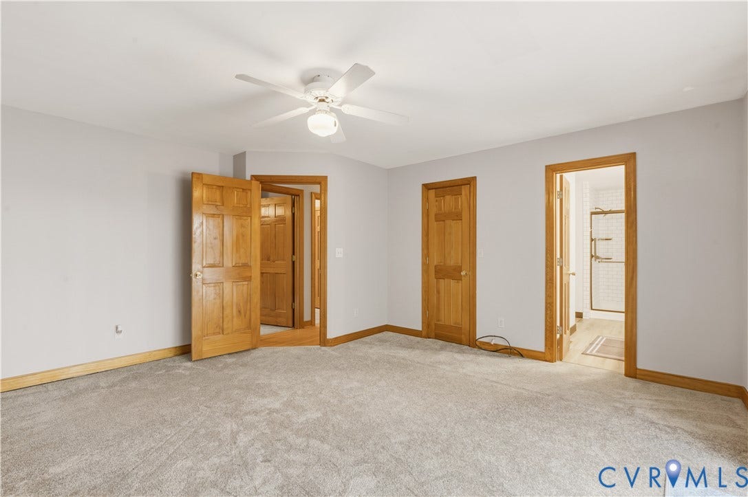 3621 Jefferson Highway, Mineral, VA 23093 Neutral-toned carpeting, six-panel wood doors, door casings with matching wood trim, and a ceiling-mounted light fixture with integrated fan