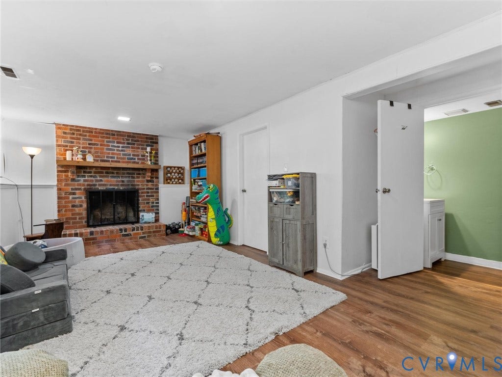 2703 Sutters Mill Court, Sutters Mill, Chesterfield, VA 23112 Brick fireplace with a wood mantel, wood-finish flooring, and a built-in vanity