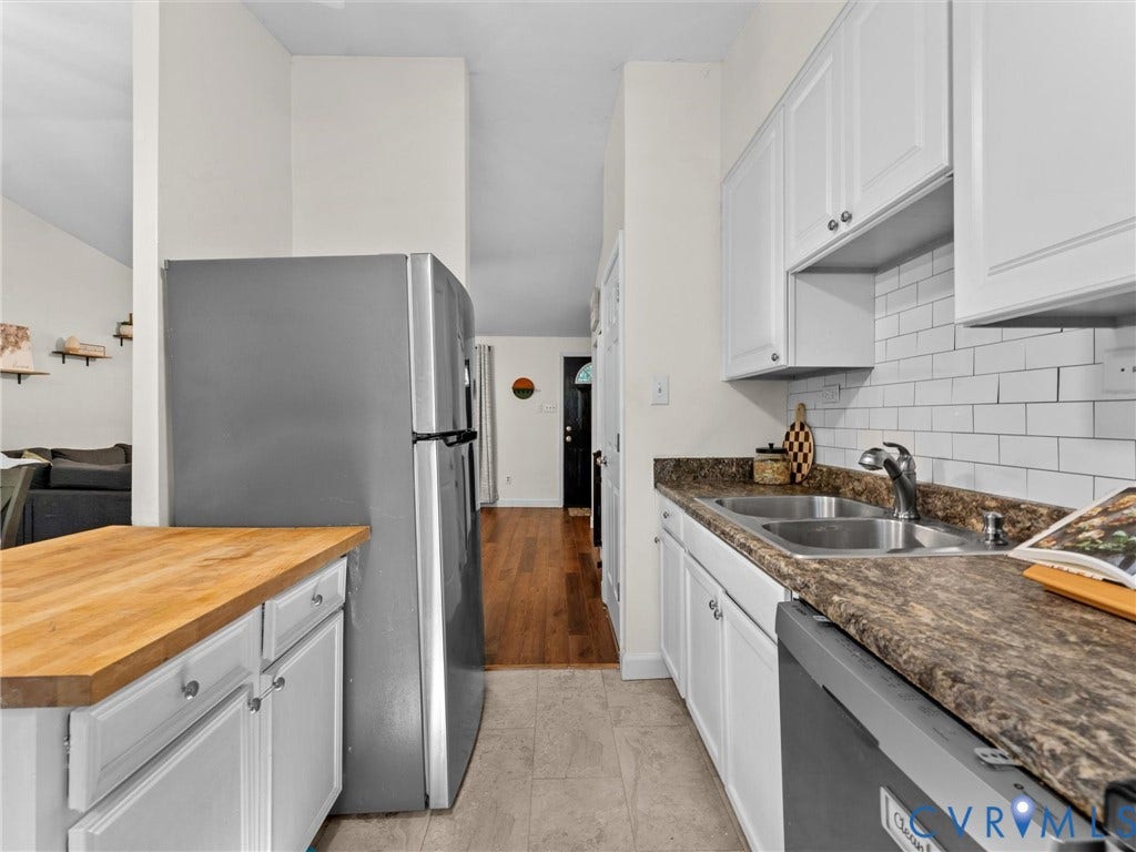2703 Sutters Mill Court, Sutters Mill, Chesterfield, VA 23112 Kitchen featuring white cabinetry, subway tile backsplash, stone-finish countertops, stainless steel appliances, and a wood-finish peninsula countertop