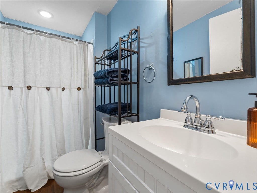 2703 Sutters Mill Court, Sutters Mill, Chesterfield, VA 23112 Bathroom vanity featuring a white cabinet base, integrated oval basin, and a two-handle chrome faucet
