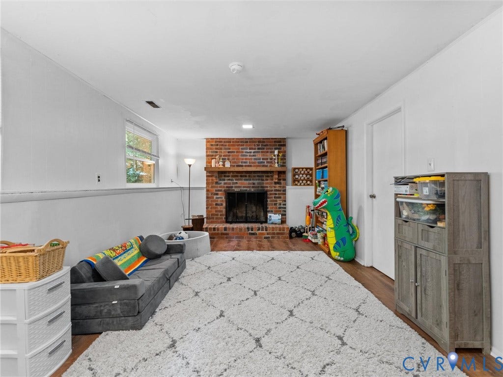 2703 Sutters Mill Court, Sutters Mill, Chesterfield, VA 23112 Brick fireplace featuring a wood mantel and metal firebox screen, accompanied by wood-finish flooring