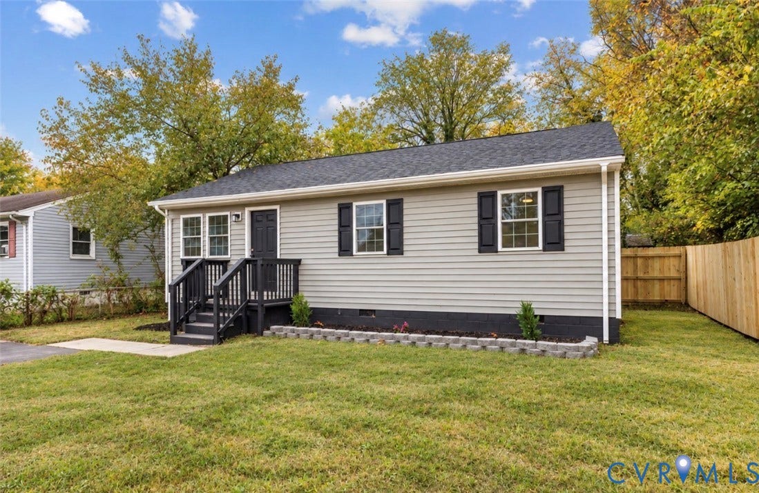 524 St Matthew Street, The Heights, Petersburg, VA 23803 Single-story exterior featuring horizontal light grey siding, dark-toned shutters, a dark shingled roof, a front porch with a wood-finish railing, and a stone-block landscape border