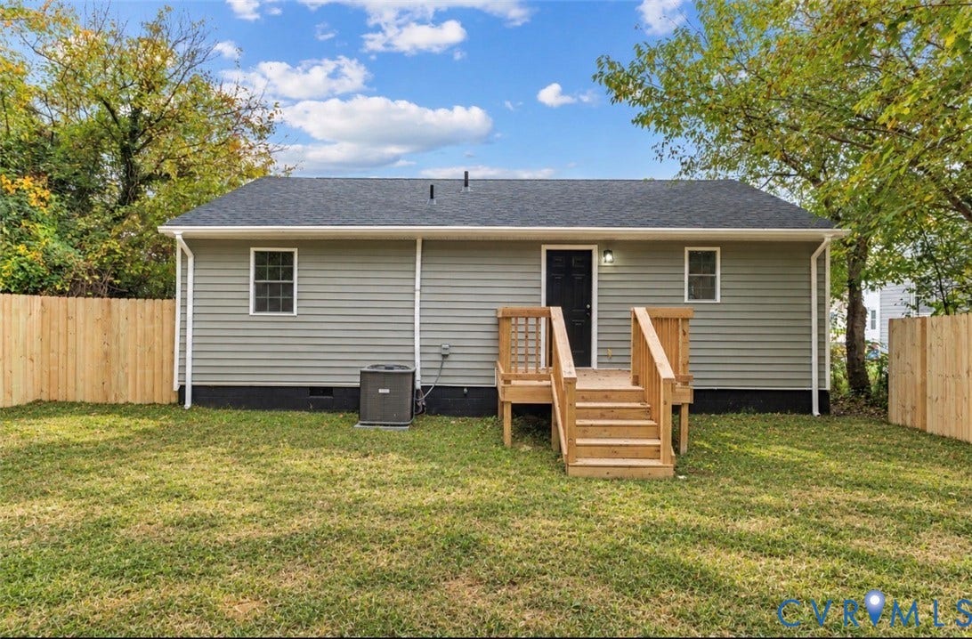 524 St Matthew Street, The Heights, Petersburg, VA 23803 Rear exterior featuring gray vinyl siding, a wooden deck with stairs, a dark-toned door, and a perimeter wood privacy fence