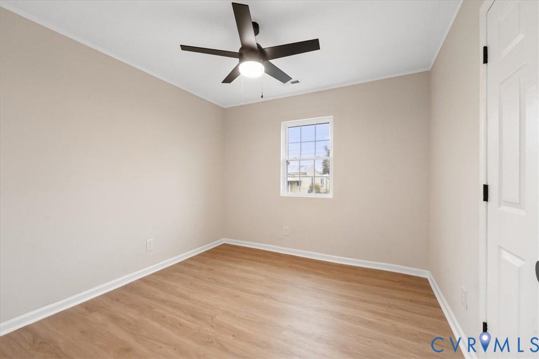 524 St Matthew Street, The Heights, Petersburg, VA 23803 Neutral-toned interior featuring wood-finish flooring, a white single-pane window, and a ceiling fan with integrated lighting
