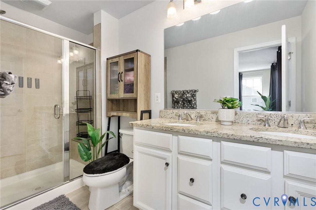 640 Rivanna Hill Road, Glen Allen, VA 23060 The private primary bath features a double-sink vanity, ample cabinet storage, and a glass-enclosed shower with tile surround.
