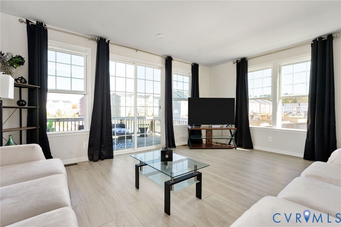 640 Rivanna Hill Road, Glen Allen, VA 23060 Open-concept area featuring light-toned wood-finish flooring, multi-pane windows, and sliding glass doors with access to an exterior deck