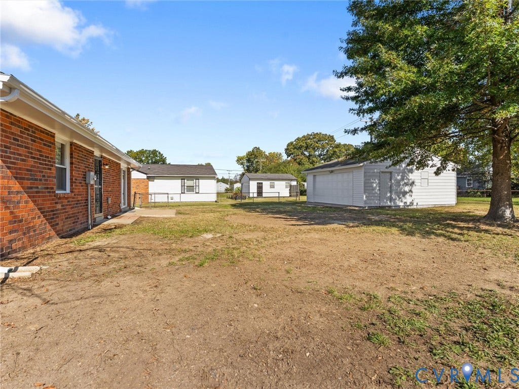 3303 Jowin Lane, Henrico, VA 23223 Red brick exterior, detached white garage, and expansive yard featuring mature trees