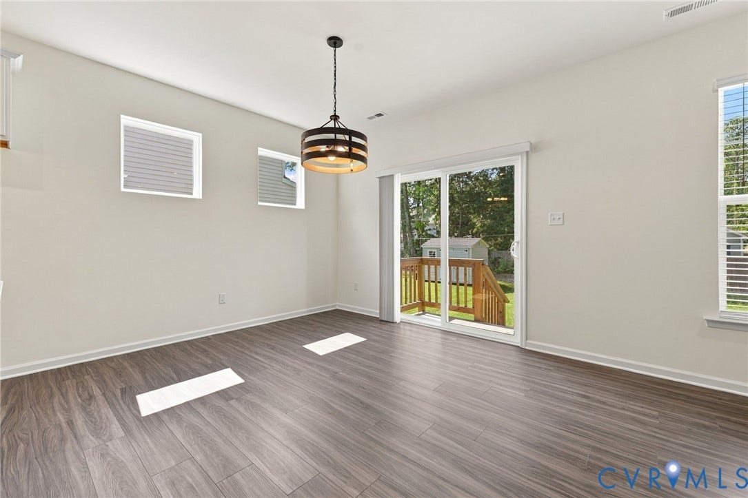 7712 Hawthorne Avenue, Henrico, VA 23227 Wood-finish flooring, industrial-style drum pendant light, multi-pane windows, and sliding glass door with exterior access