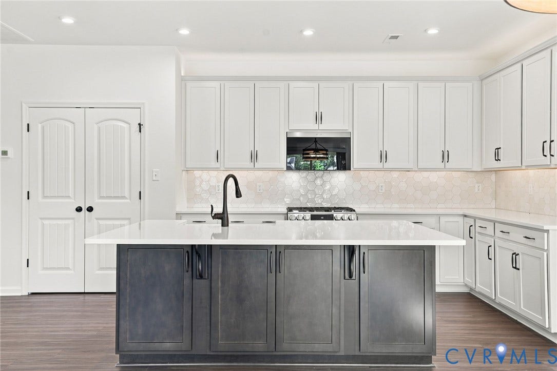 7712 Hawthorne Avenue, Henrico, VA 23227 Kitchen featuring a center island with a stone countertop and dark-finish cabinetry, white wall-mounted cabinetry, hexagonal tile backsplash, wood-finish flooring, and a matte black gooseneck faucet