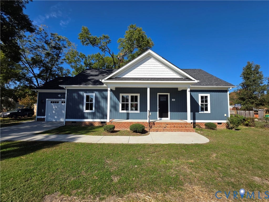 3005 Portsmouth Street, Hopewell, VA 23860 Blue vertical siding exterior featuring a covered front porch, brick foundation detailing, attached garage, and a concrete walkway