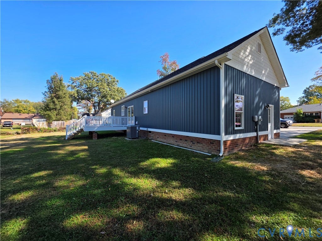 3005 Portsmouth Street, Hopewell, VA 23860 Exterior profile featuring vertical siding, a brick foundation, a white deck, and a peaked roofline
