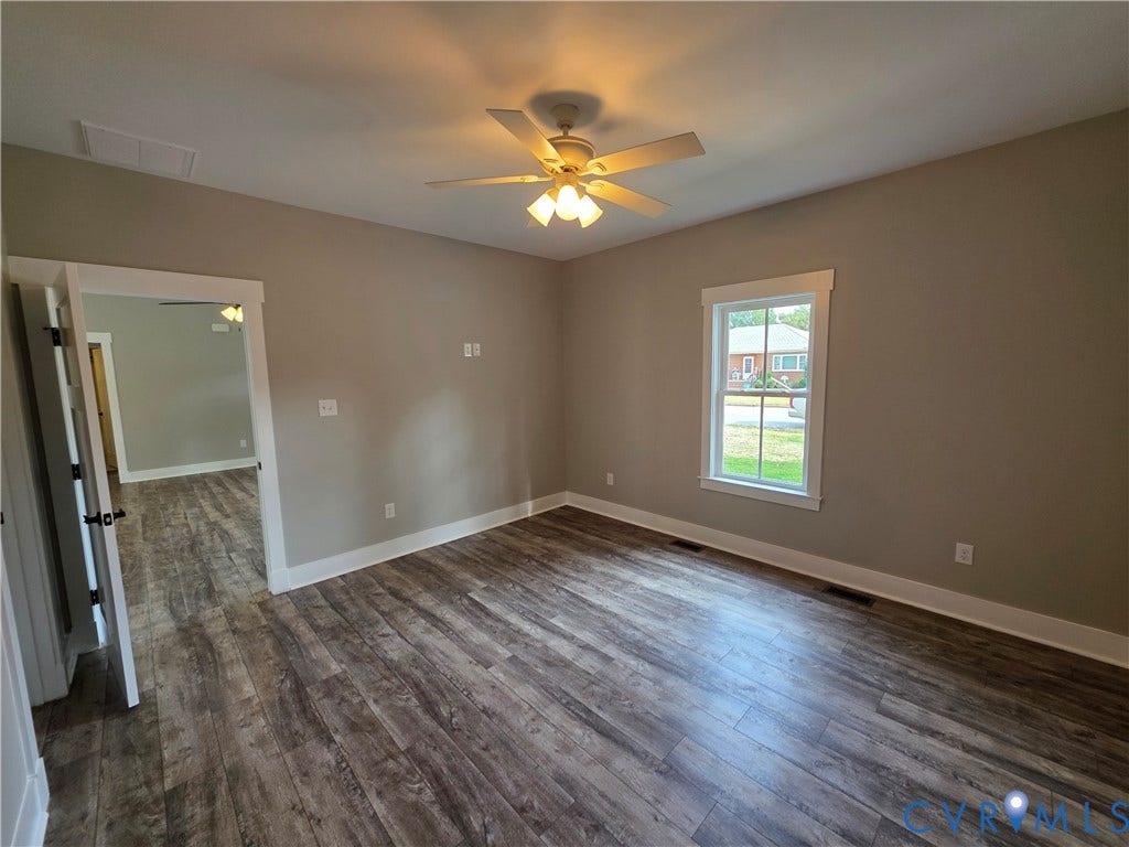 3005 Portsmouth Street, Hopewell, VA 23860 Neutral-toned room featuring wood-finish flooring, a multi-blade ceiling fan with integrated lighting, and a window with white trim