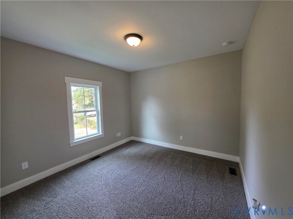 3005 Portsmouth Street, Hopewell, VA 23860 Neutral-toned walls, wall-to-wall carpeting, single-hung window with white casing, and flush-mount ceiling light fixture