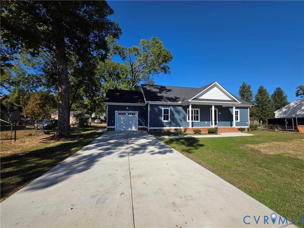 3005 Portsmouth Street, Hopewell, VA 23860 Single-story exterior featuring blue siding, a covered front porch with white columns, a shingled roof, and an attached garage with a concrete driveway