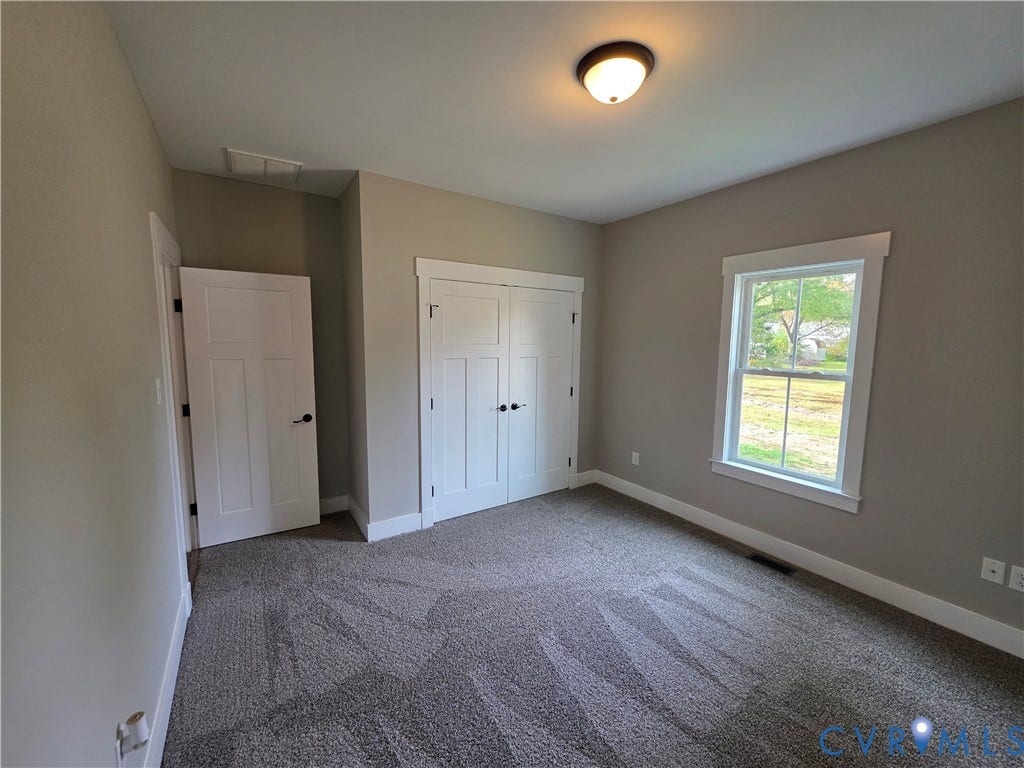 3005 Portsmouth Street, Hopewell, VA 23860 Interior room featuring neutral wall tones, double-door closet cabinetry, a multi-pane window with white trim, and plush carpeting