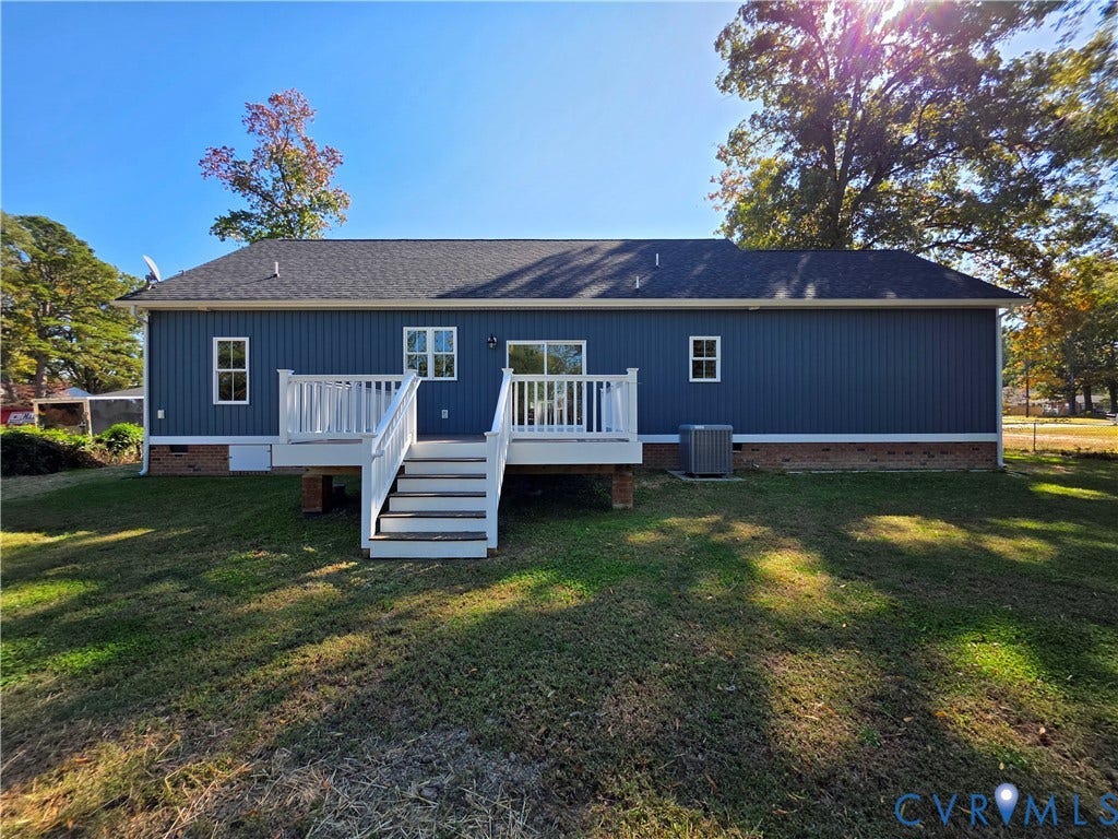 3005 Portsmouth Street, Hopewell, VA 23860 Exterior featuring blue vertical siding, a raised white deck with stairs, a brick foundation base, and a shingled roof